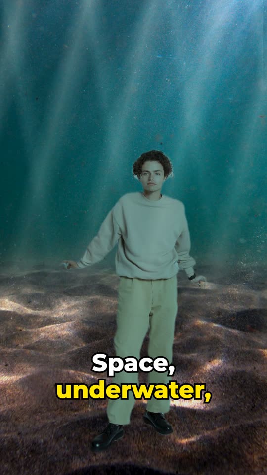 The man standing in front of a glowing underwater scene with light rays.